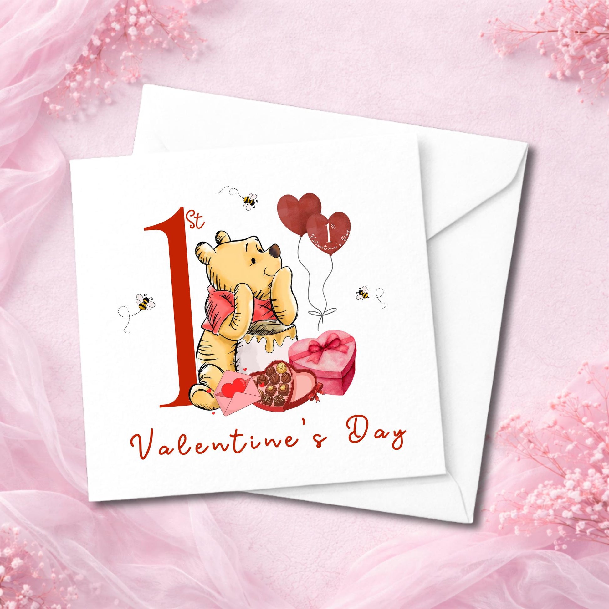 High-quality baby Valentine card with cuddly bear holding a heart. Surrounded by heart balloons, honey, and chocolates. Red number one and text on a white background. Smooth or hammered finish. Flat lay with envelope and soft feminine styling.