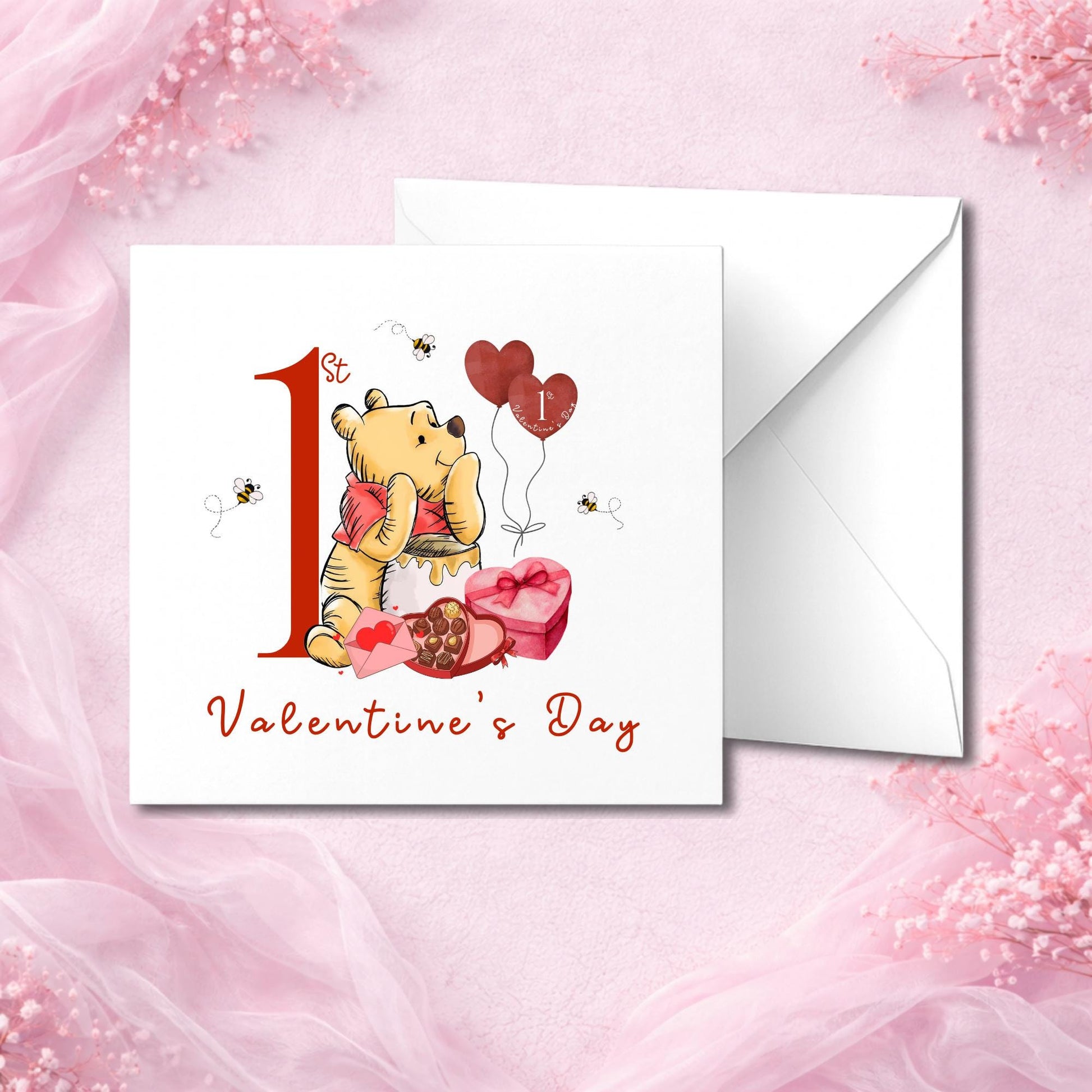 Flat lay image of baby’s first Valentine’s card with bear hugging a red heart, sitting next to honey pot and chocolates. Red number “1” with elegant font and Valentine’s details. Comes with white envelope. Great keepsake for new parents or baby’s memory box.