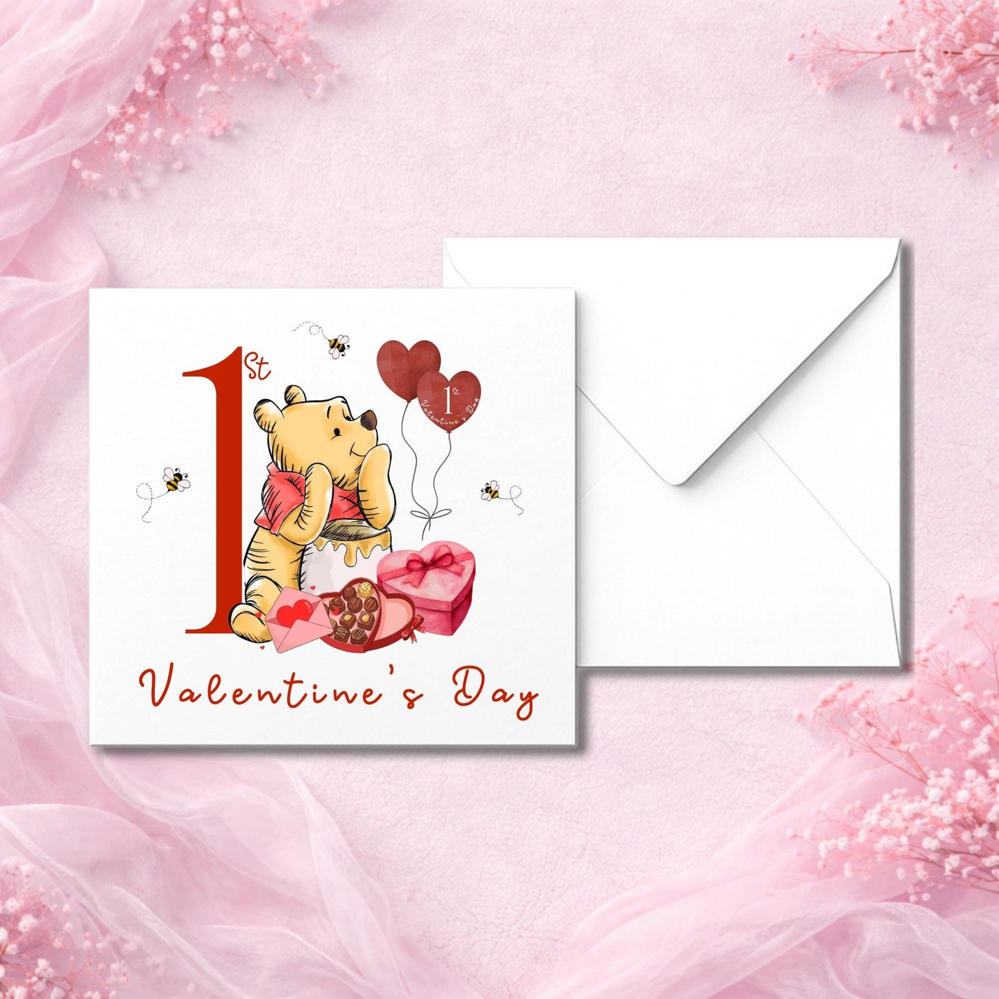 Valentine’s card for a baby featuring bear character holding heart and honey, surrounded by bees and gifts. Card says “1st Valentine’s Day” in red text. Perfect for gifting to new parents. Photographed flat lay with white envelope on soft pink fabric. Printed on thick smooth or hammered cardstock.