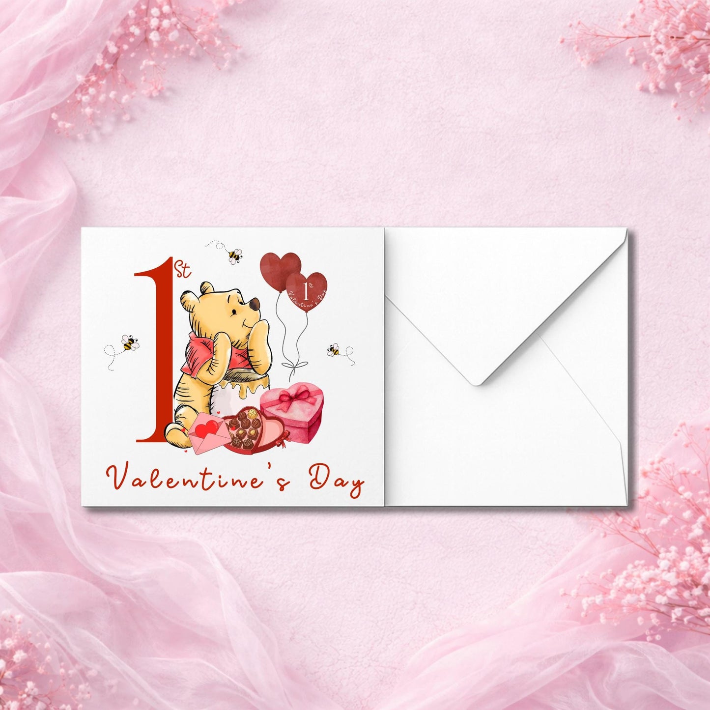 Cute bear-inspired baby Valentine card with heart-shaped balloons and honey pot. Design includes chocolates and buzzing bees. Premium quality card with envelope, perfect for baby’s first Valentine. Suitable for baby girl or boy. Flat lay on pink background with florals.