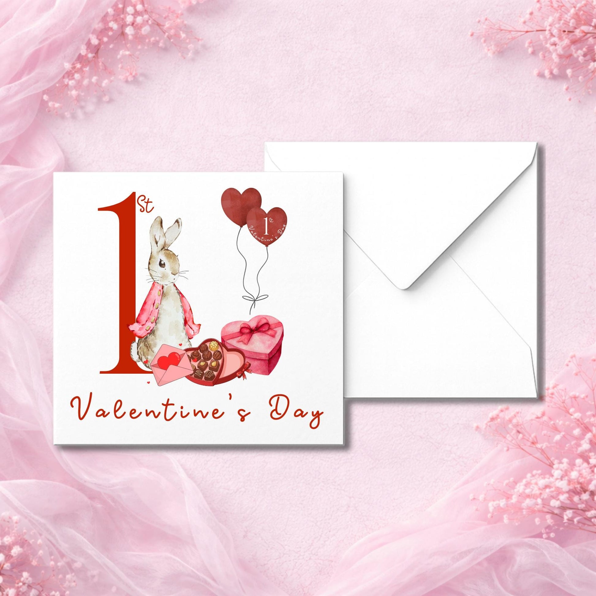 Valentine’s card for a new baby, with a sweet watercolour-style bunny and love-themed gifts. Features red “1st Valentine’s Day” text and floating heart balloons. Card is printed on white luxury cardstock and paired with a white envelope. Shot in a flat lay style with pink chiffon background. Ideal for baby’s first Valentine’s celebration, gift from family or friend.