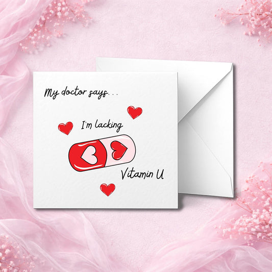 A luxury handmade Valentine’s card featuring a red and pink capsule with heart shapes and the text “I’m lacking Vitamin U.” Card is printed on premium hammered white cardstock and photographed flat lay on a pink chiffon background with white envelope, designed as a romantic keepsake gift for boyfriend, girlfriend, husband, wife, or partner. Ideal for Valentine’s Day or anniversaries.